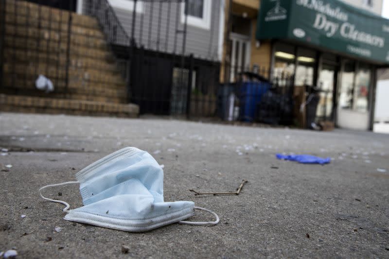 Protective glove and mask seen discarded on city sidewalk during outbreak of coronavirus disease (COVID-19) in Brooklyn New York