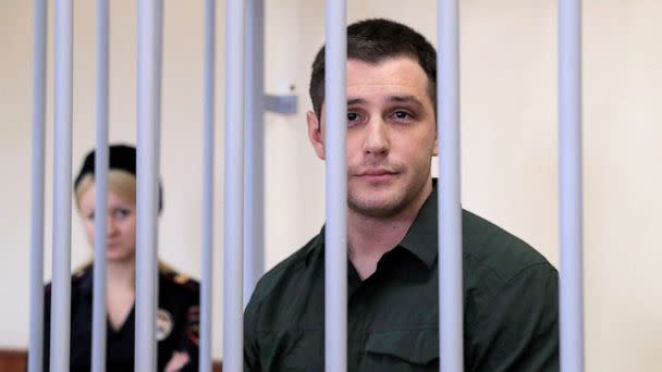 PHOTO: Former U.S. Marine Trevor Reed, who was detained in 2019 and accused of assaulting police officers, stands inside a defendants' cage during a court hearing in Moscow, March 11, 2020. (Tatyana Makeyeva/Reuters, FILE)