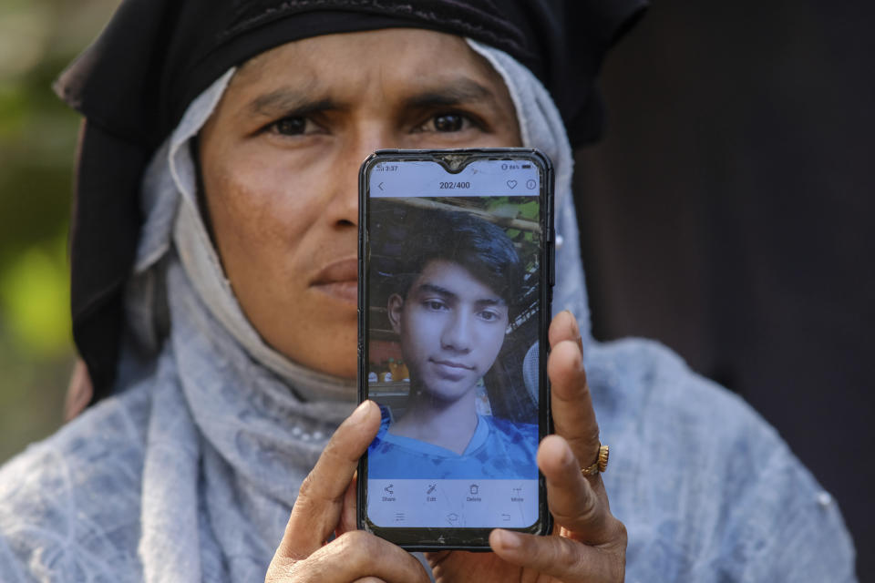 Romeda Begum shows a photo of her 18-year-old son, Kabir Ahmed, who was on board a boat of 180 Rohingya refugees that vanished in December 2022, during an interview in the Nayapara refugee camp in Teknaf, part of the Cox's Bazar district of Bangladesh, on March 8, 2023. (AP Photo/Mahmud Hossain Opu)