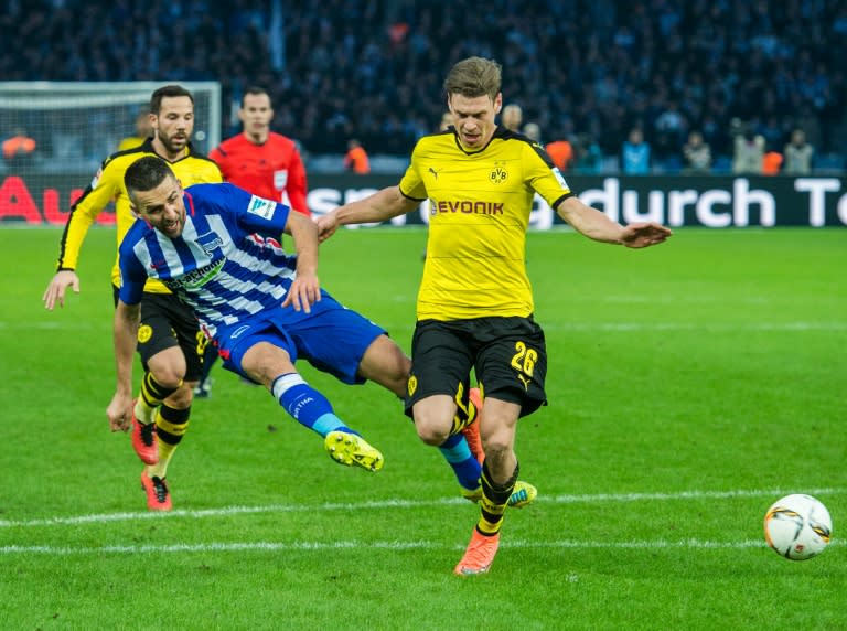 Hertha Berlin’s forward Vedad Ibisevic (L) has a shot blocked by Dortmund's defender Lukasz Piszczek during the German first division Bundesliga football match at the Olympic stadium in Berlin on February 6, 2016