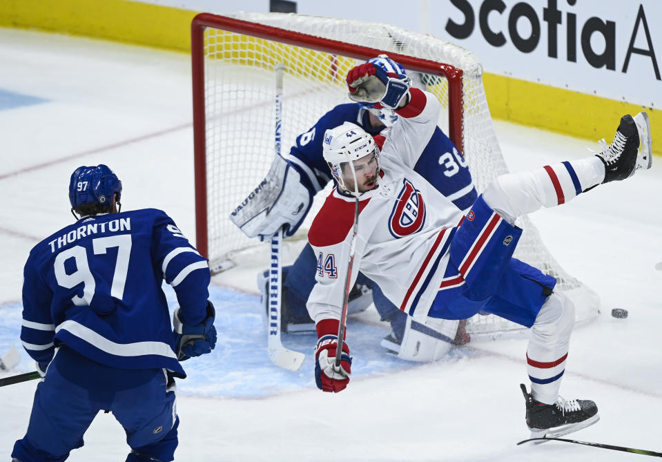 Montreal Canadiens defenseman Joel Edmundson (44) gets tripped as Toronto Maple Leafs forward Joe Thornton (97) looks for the puck during the first period of an NHL hockey game Saturday, May 8, 2021, in Toronto. (Nathan Denette/The Canadian Press via AP)