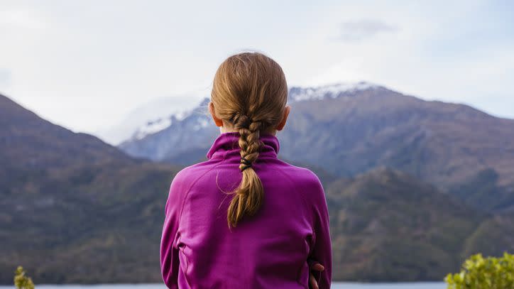 red haired girl looking at view and her hair is in a french braid