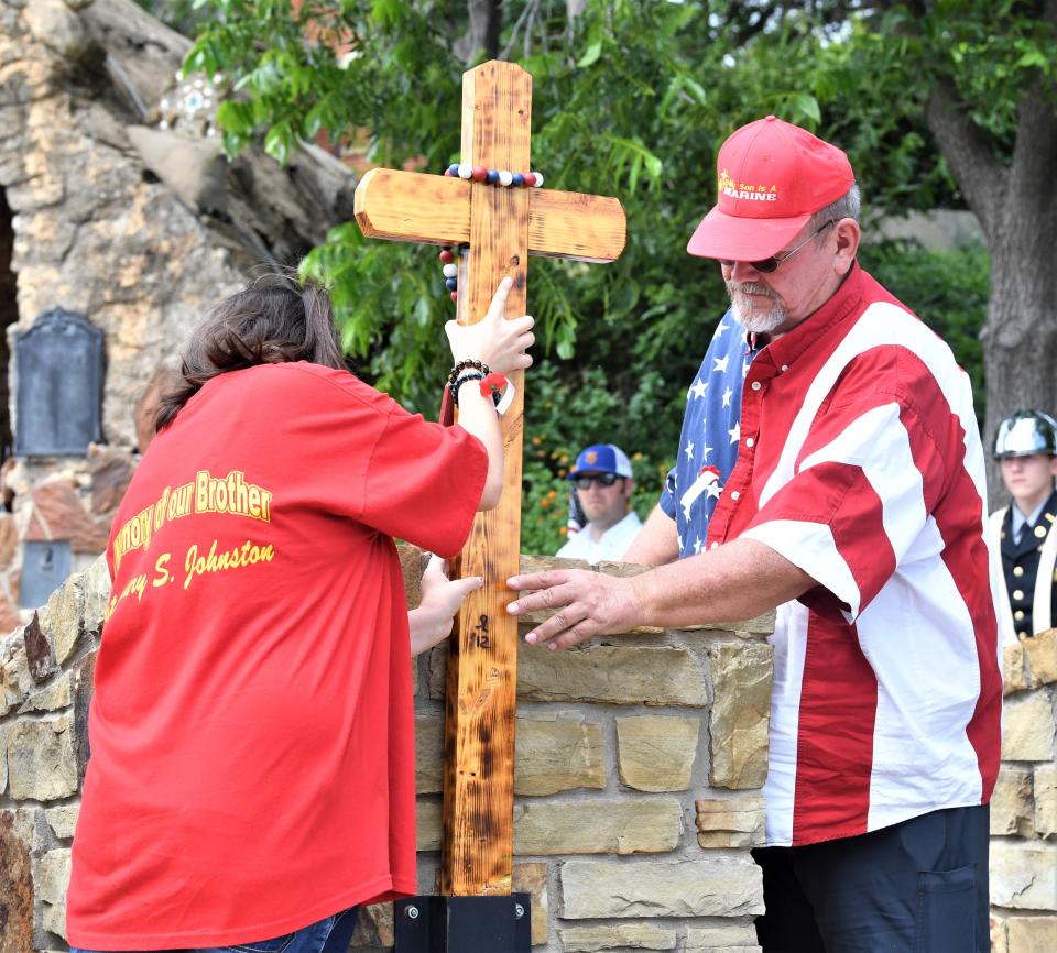 A cross is assembled at a gravestone during a Memorial Day Ceremony in Windthorst on Monday, May 29, 2023.