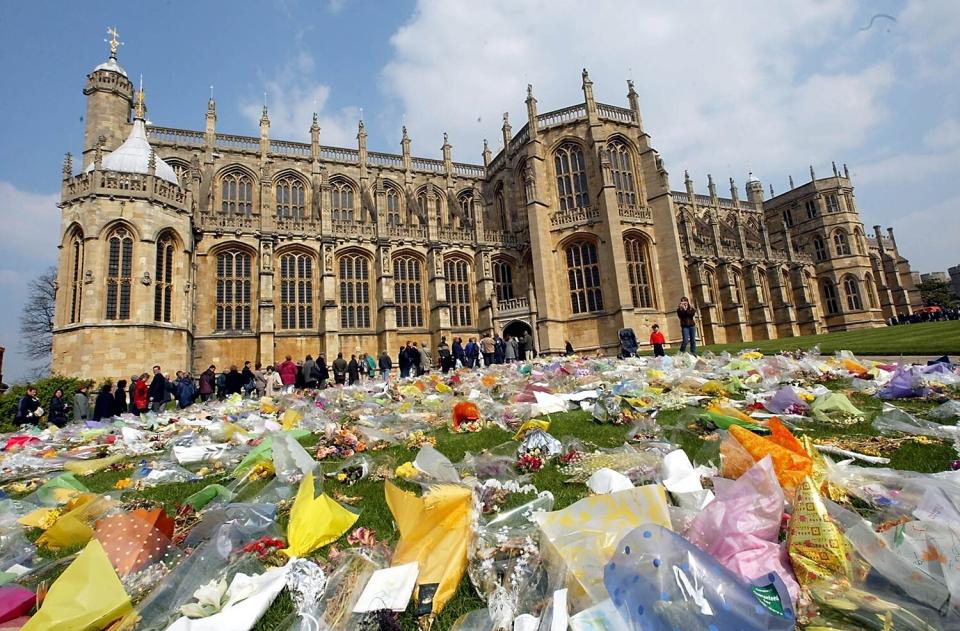 A queue of mourners snakes around the floral tributes outside St. Georges Chapel, at Windsor Casle, 10 April 2002, as people wait in line to view the tomb of the late Queen Mother, who was buried next to her husband King George VI. The Queen Mum died at the age of 101 on March 30.