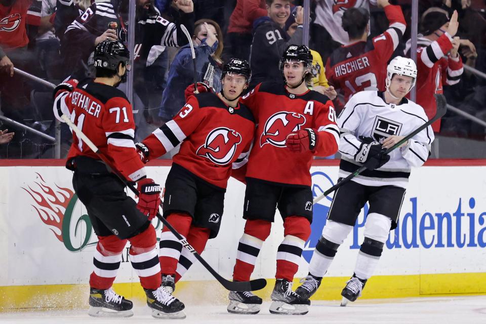 New Jersey Devils left wing Jesper Bratt (63) celebrates with teammates in front of Los Angeles Kings defenseman Tobias Bjornfot (7) after scoring a goal during the first period of an NHL hockey game Sunday, Jan. 23, 2022, in Newark.