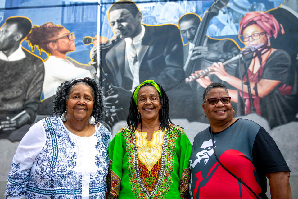 Sisters of Pee Wee Ellis, pose for a portrait by the Clarissa Street Uprooted Mural underneath the I-490 Highway before it’s unveiling in Rochester, N.Y. on Aug. 17, 2023.