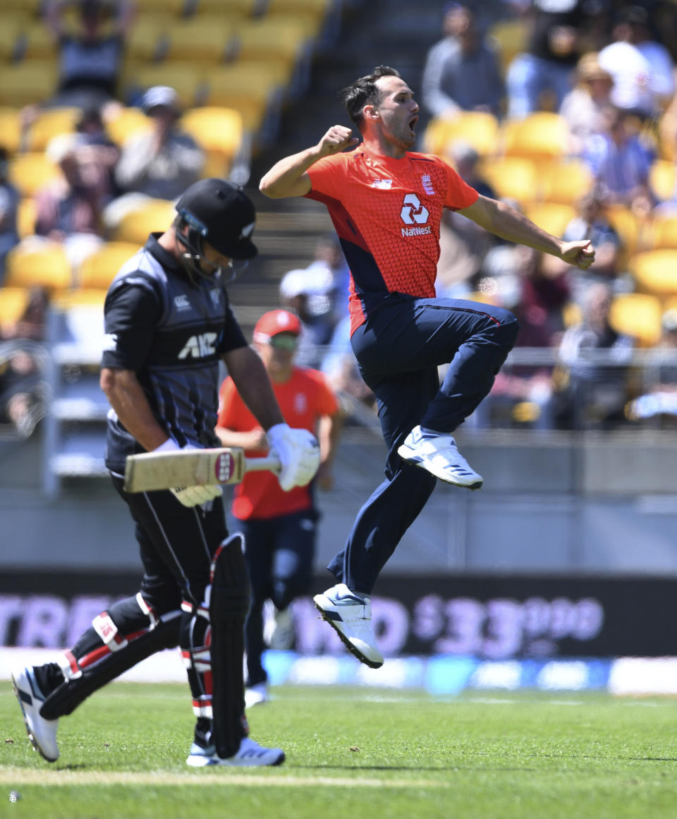 England's Lewis Gregory celebrates his international debut wicket of New Zealand's Colin de Grandhomme, left, for 28 as he walks during the T20 cricket game between England and New Zealand in Wellington, New Zealand, Sunday, Nov. 3, 2019. (AP Photo/Ross Setford)