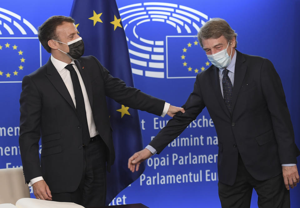 French President Emmanuel Macron, left, holds the arm of European Parliament President David Sassoli during the Europe Day event and the Conference on the Future of Europe, Sunday, May 9, 2021 at the European Parliament in Strasbourg, eastern France. (Frederick Florin, Pool via AP)