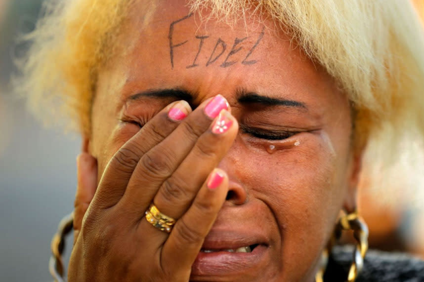 <p>Eine Frau, auf deren Stirn "Fidel" geschrieben steht, weint, als sie gemeinsam mit Tausenden Kubanern am Uferboulevard Malecón um den verstorbenen Präsidenten Fidel Castro trauert. (Bild: Chip Somodevilla/Getty Images) </p>