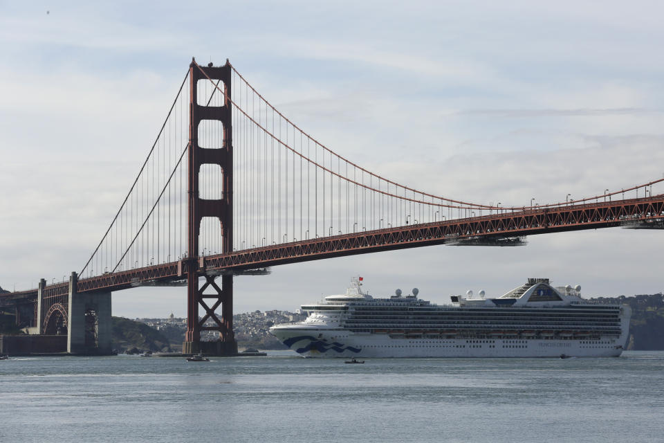 The Grand Princess cruise ship passes beneath the Golden Gate Bridge in this view from Sausalito, Calif., Monday, March 9, 2020. The cruise ship carrying over a dozen people infected with the coronavirus passed under the bridge as federal and state officials in California prepared to receive thousands of people on the ship that has been idling off the coast of San Francisco. (AP Photo/Eric Risberg)