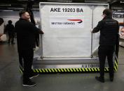 Workers adjust a baggage holder on one of the company's autonomous 'Auto-Dolly' baggage transporter at the Aurrigo factory in Coventry