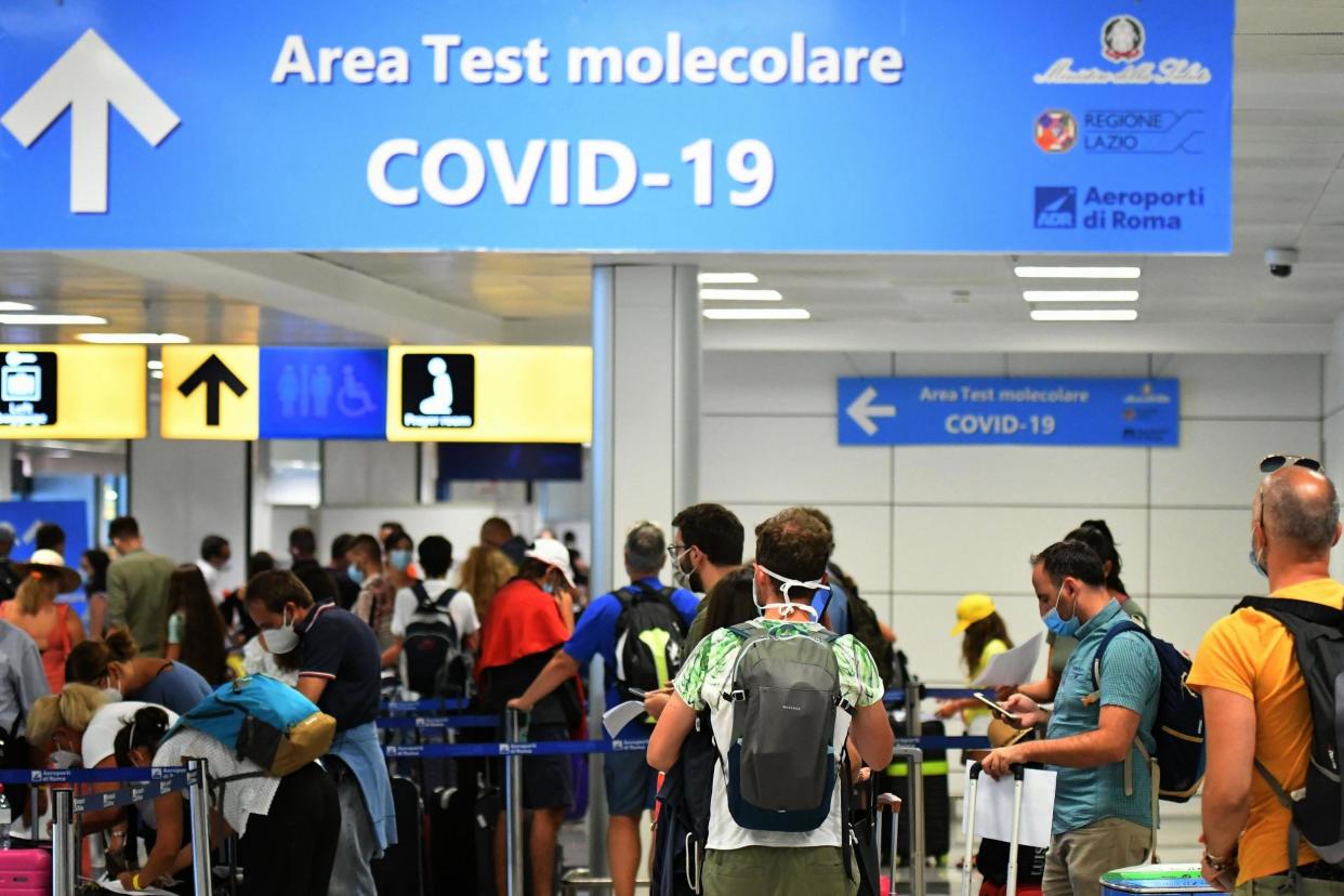 Passengers queue to be screened for Covid-19 at a testing station set up at Fiumicino airport, near Rome: AFP via Getty Images