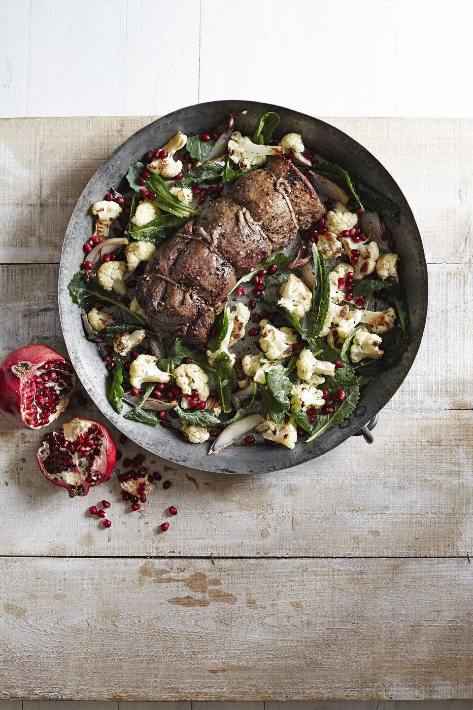 beef tenderloin with roasted cauliflower salad in a large metal serving bowl