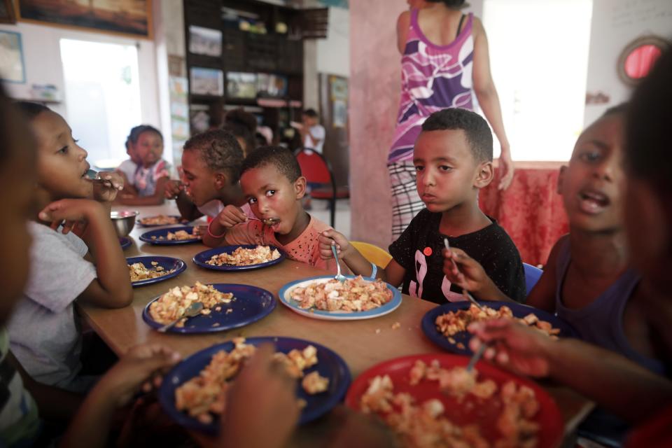 The children of African Eritrean migrants eat lunch at a makeshift kindergarten in southern Tel Aviv&nbsp;in September 2017. Tens of thousands of Africans who fled misery at home for safety in Israel are living in limbo, fearing deportation though some have lived in the country for more than a decade. (Photo: MENAHEM KAHANA via Getty Images)