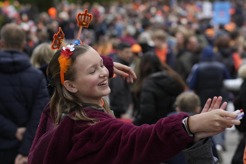 A girl jokes with a friend as they offer to decorate faces in the red-white-blue colors of the national flag during King's Day celebrations in Amsterdam, Netherlands, Wednesday, April 27, 2022. After two years of celebrations muted by coronavirus lockdowns, the Netherlands marked the 55th anniversary of King Willem-Alexander with street parties, music festivals and a national poll showing trust in the monarch ebbing away. (AP Photo/Peter Dejong)