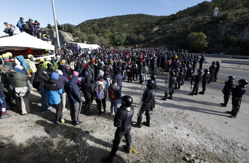 Members of Catalan protest group Democratic Tsunami gather as Catalan policemen Mossos stand guard at the AP-7 highway