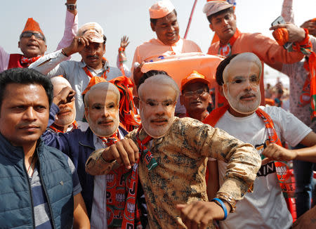 Supporters of India's ruling Bharatiya Janata Party (BJP) wearing masks of Prime Minister Narendra Modi attend an election campaign rally being addressed by Modi in Meerut in the northern Indian state of Uttar Pradesh, India, March 28, 2019. REUTERS/Adnan Abidi