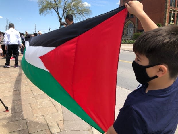 A young boy shows his support for the Palestinians at a rally in Fredericton on Sunday. 