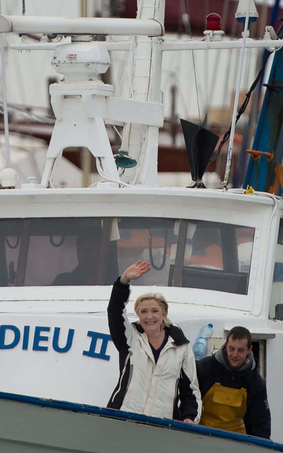 French presidential election candidate for the far-right Front National (FN) party Marine Le Pen (L) gestures aboard a fishing boat after meeting fishermen in the harbour of Le Grau-du-Roi, southern France, - Credit:  BERTRAND LANGLOIS/AFP