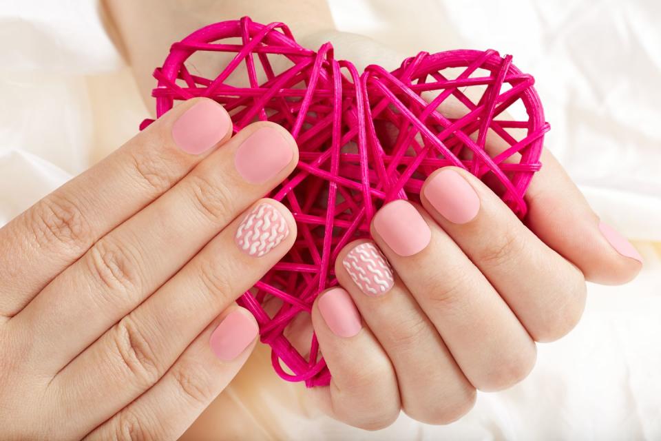 <p>This matte pink manicure is kept from going too sweet with a simple white cable-knit design on the ring fingers.</p>