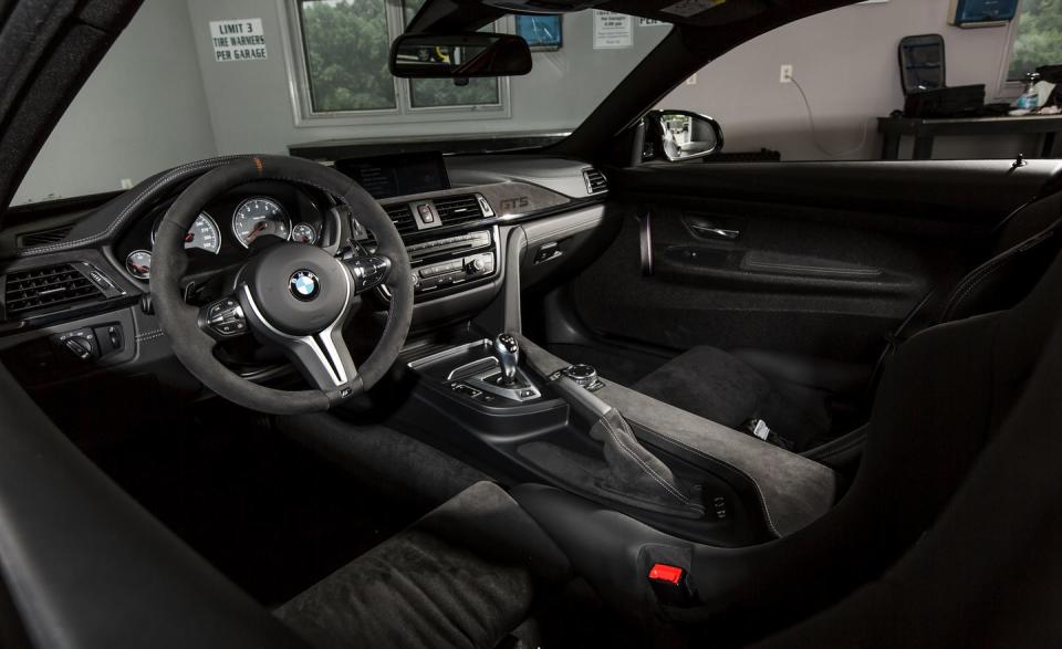 Inside, there are few comforts. Microsuede trims many interior surfaces, including the dash. Note the lack of a center-console bin. Beneath the dash is a carbon-fiber support tube to further reduce mass. Unfortunately, all the weight savings are offset by components added to make the GTS into the hellbeast it is. This car weighs 3538 pounds, or just 43 pounds lighter than <a href="http://www.caranddriver.com/features/bmw-m4-at-lightning-lap-2014-feature" rel="nofollow noopener" target="_blank" data-ylk="slk:the 2014 M4 we lapped at VIR;elm:context_link;itc:0;sec:content-canvas" class="link ">the 2014 M4 we lapped at VIR</a> two years ago.