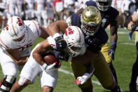 Notre Dame defensive lineman Howard Cross III, right, tackles Wisconsin running back Chez Mellusi for a loss during the first half of an NCAA college football game Saturday, Sept. 25, 2021, in Chicago. (AP Photo/Charles Rex Arbogast)