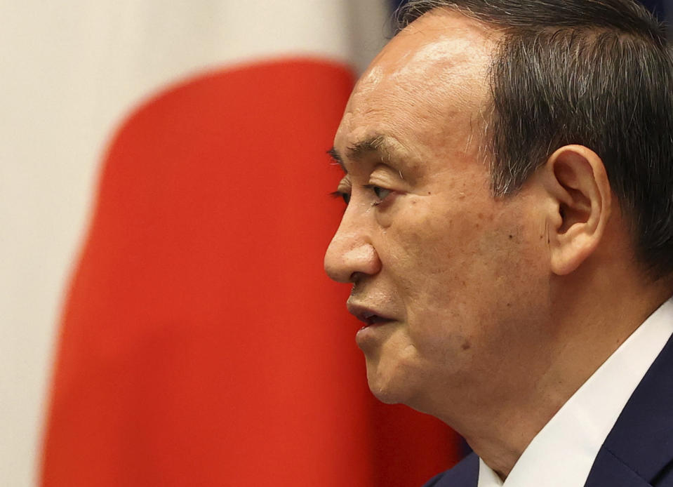 Japan's Prime Minister Yoshihide Suga attends a news conference on Japan's response to the coronavirus pandemic at his official residence during the Tokyo 2020 Olympic Games in Tokyo, Japan, Friday, July 30, 2021. Suga expanded a coronavirus state of emergency to four more areas in addition to Tokyo on Friday following record spikes in infections as the capital hosts the Olympics. (Issei Kato/Pool Photo via AP)