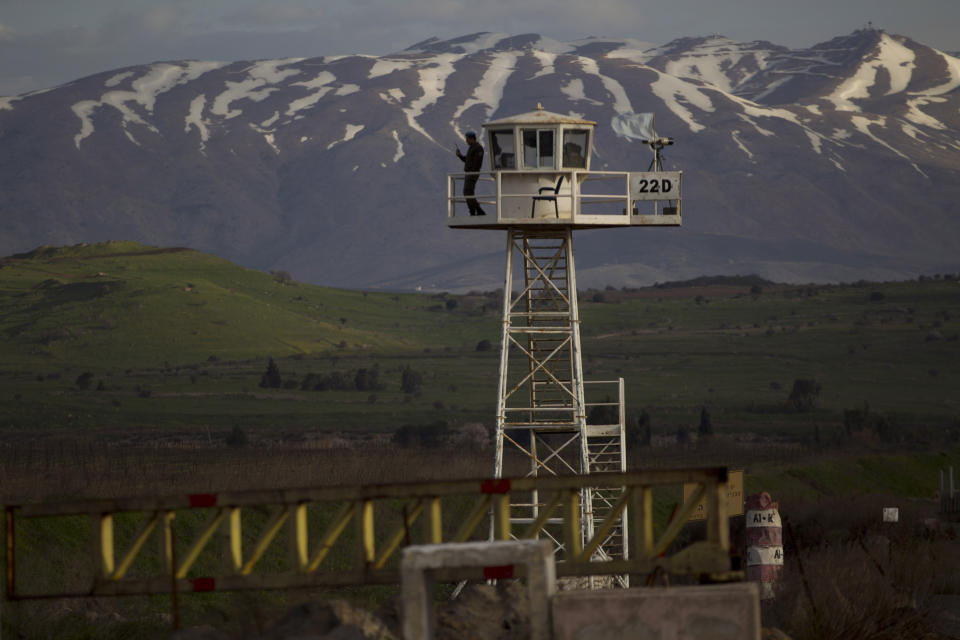 FILE - In this March 8, 2013, file photo, a U.N. peacekeeper stands guard on a watch tower at the Quneitra Crossing between Syria and the Israeli-controlled Golan Heights. The Golan Heights is a strategic high ground at the southwestern corner of Syria with stunning, broad views of both Israel and Syria below. (AP Photo/Ariel Schalit, File)