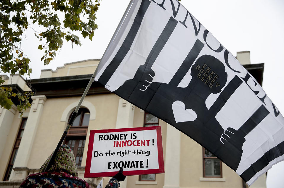 A woman holds a flag and sign during a protest against the execution of Rodney Reed on Wednesday, Nov. 13, 2019, in Bastrop, Texas. Protesters rallied in support of Reed’s campaign to stop his scheduled Nov. 20 execution or the 1996 killing of a 19-year-old Stacy Stites. The protesters rallied outside the Bastrop County district attorney’s office in Bastrop, about 30 miles southeast of Austin. (Nick Wagner/Austin American-Statesman via AP)