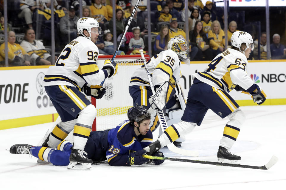 St. Louis Blues left wing Zach Sanford (12) falls between Nashville Predators' Ryan Johansen (92) and Mikael Granlund (64), of Finland, in the first period of an NHL hockey game Sunday, Feb. 16, 2020, in Nashville, Tenn. (AP Photo/Mark Humphrey)