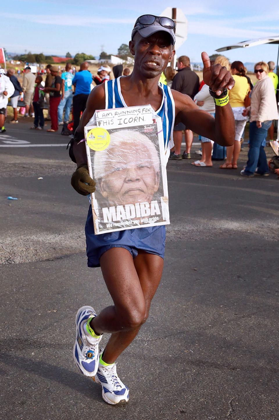 A runner holds a portrait of Nelson Mandela.