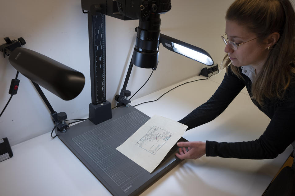 Annet Waalkens, researcher at the National Archive of the Netherlands, displays the map where the Nazi loot was reportedly buried in Ommeren, near Arnhem, in The Hague, Monday, Jan. 23, 2023. A hand-drawn map with a red letter X purportedly showing the location of a buried stash of precious jewelry looted by Nazis from a blown-up bank vault has sparked a modern-day treasure hunt in a tiny Dutch village. (AP Photo/Peter Dejong)