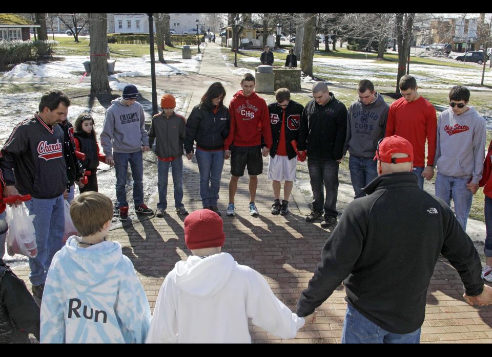 A group of students and parents pray for victims of a school shooting on the square in Chardon, Ohio on Feb. 28, 2012. A gunman opened fire inside the Chardon High School cafeteria at the start of the school day Monday. Three of the victims have died and two others remain wounded.