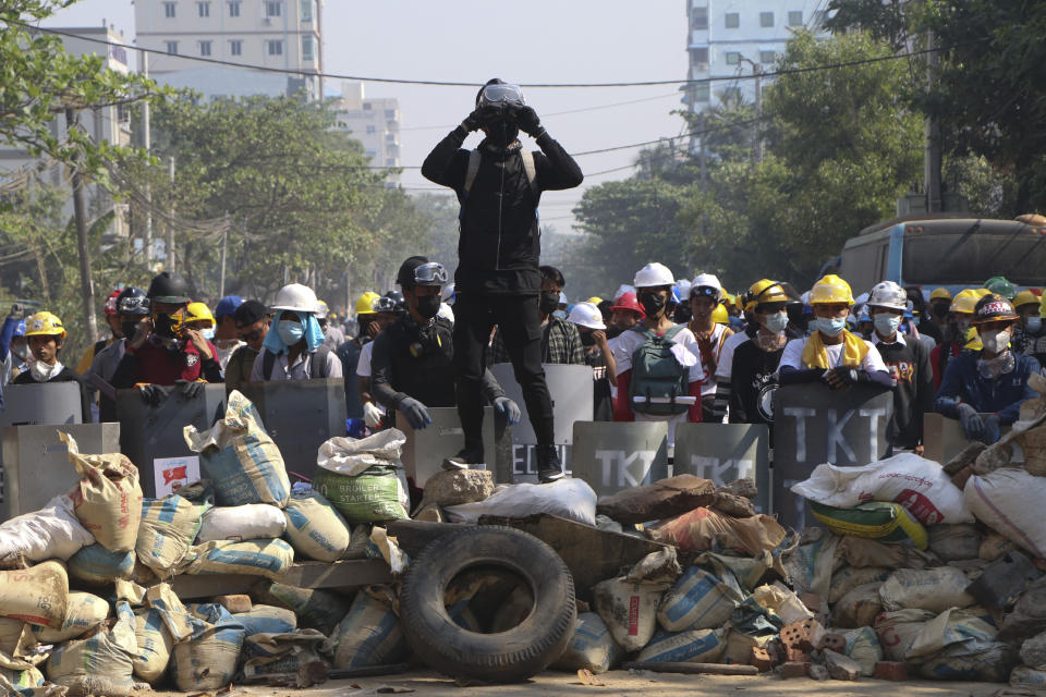 Protesters take positions behind a barricades as police gather in Yangon, Myanmar, Sunday, March 7, 2021. The escalation of violence in Myanmar as authorities crack down on protests against the Feb. 1 coup is raising pressure for more sanctions against the junta, even as countries struggle over how to best sway military leaders inured to global condemnation. (AP Photo)