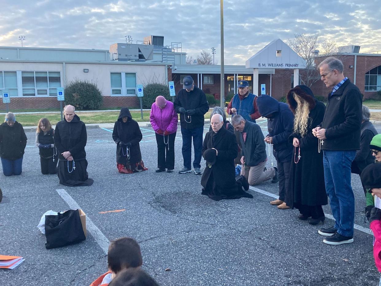 Pastors lead a prayer group outside B.M. Williams Primary in response to the plans for an after-school Satan club on Dec. 4, 2022.