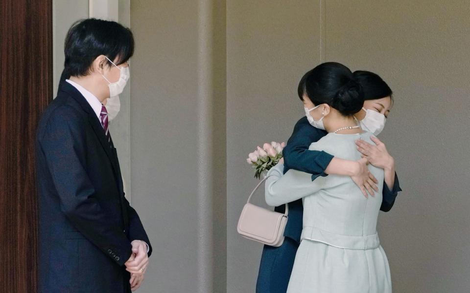 Mako hugs her sister Princess Kako before leaving her home in Tokyo - AFP