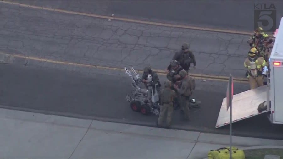 Bomb squad members prepare robots to inspect a Wells Fargo bank in Fullerton after a bomb threat on March 26, 2024. (KTLA)