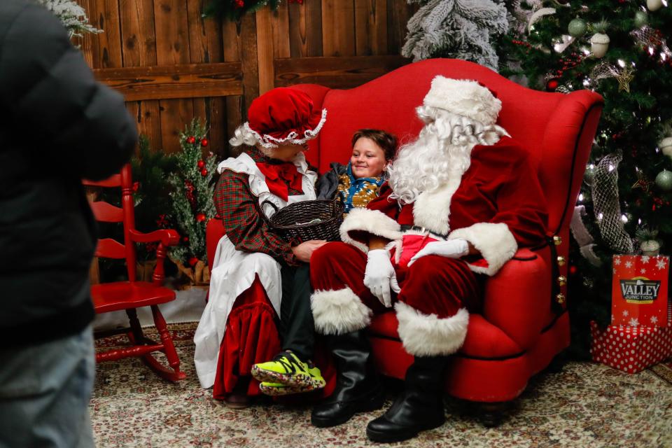 Bennett Thompson (6) tells Mrs. Claus and Santa what he wants for Christmas during the Jingle in the Junction at the Historic Valley Junction in 2022.