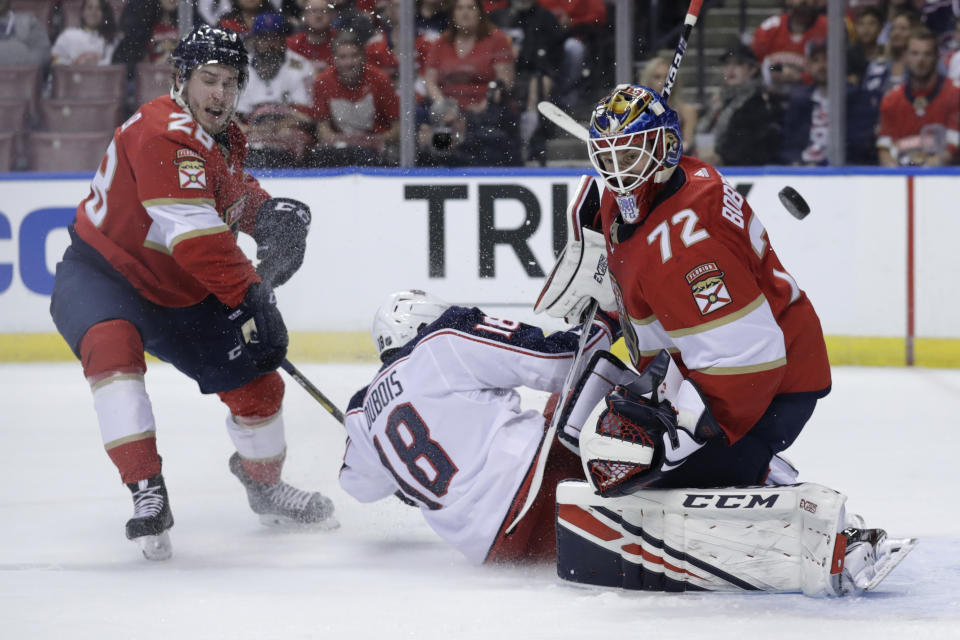 Florida Panthers goaltender Sergei Bobrovsky (72) defends the goal as Columbus Blue Jackets center Pierre-Luc Dubois (18) collides with him during the first period of an NHL hockey game, Saturday, Dec. 7, 2019, in Sunrise, Fla. Panthers' Aleksi Saarela (28) looks on. (AP Photo/Lynne Sladky)