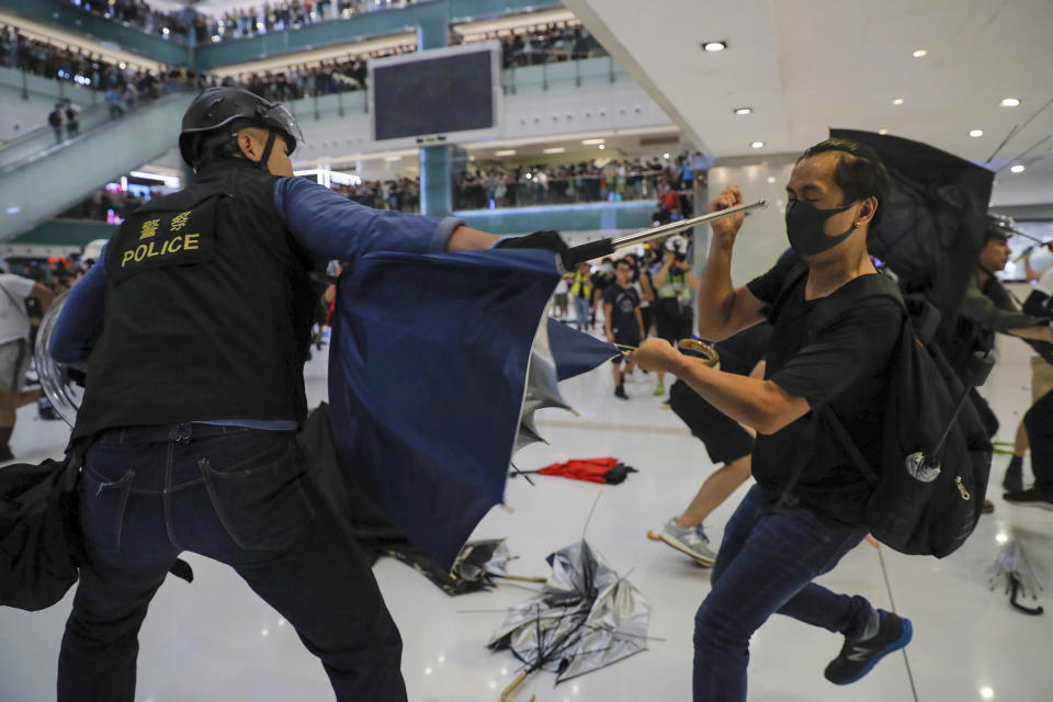 A policeman scuffles with a protester inside a mall in Sha Tin District in Hong Kong, Sunday, July 14, 2019. Police in Hong Kong have fought with protesters as they broke up a demonstration by thousands of people demanding the resignation of the Chinese territory's chief executive and an investigation into complains of police violence. (AP Photo/Kin Cheung)