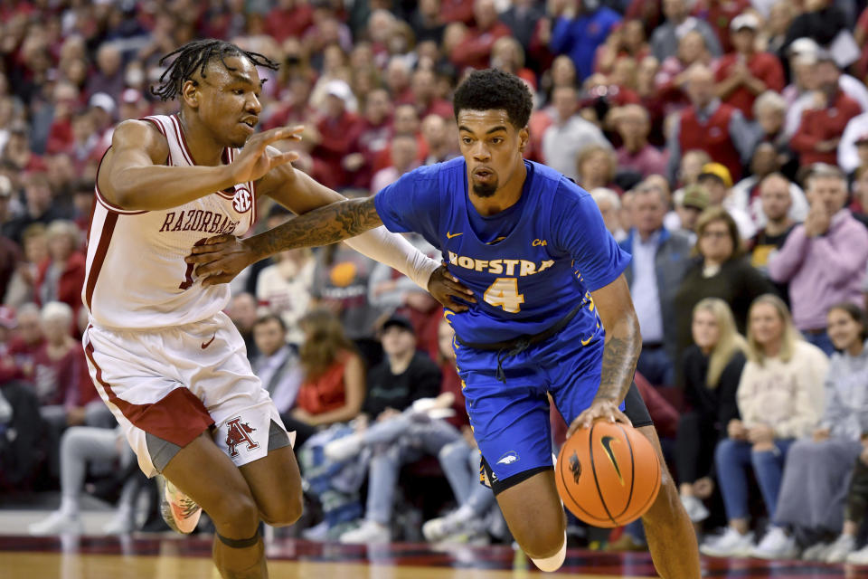 FILE - Hofstra guard Aaron Estrada (4) drives past Arkansas guard JD Notae (1) during the second half of an NCAA college basketball game on Dec. 18, 2021, in Little Rock, Ark. The Oregon transfer was the Colonial Athletic Association player of the year last season in his first year at Hofstra. Estrada led the CAA in scoring (18.5) and assists (5.0) and also had 5.7 rebounds and 1.5 steals per game. (AP Photo/Michael Woods, File)