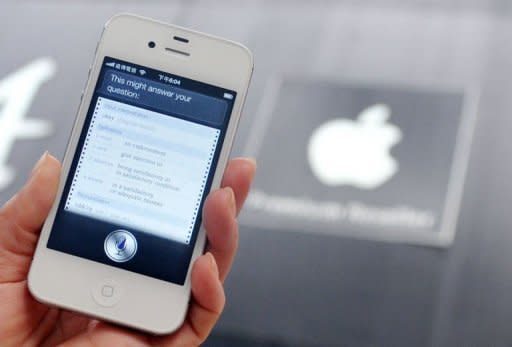 A woman displays "Siri" voice-activated assistant technology on an Apple iPhone 4S in Taipei. Lawyers for Apple and Samsung debated the differences between copying and honest competition as opening arguments were held Tuesday in a huge patent trial involving the two tech giants