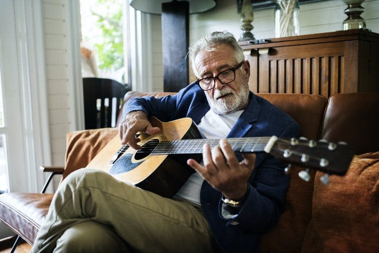 Image of a man playing the guitar.