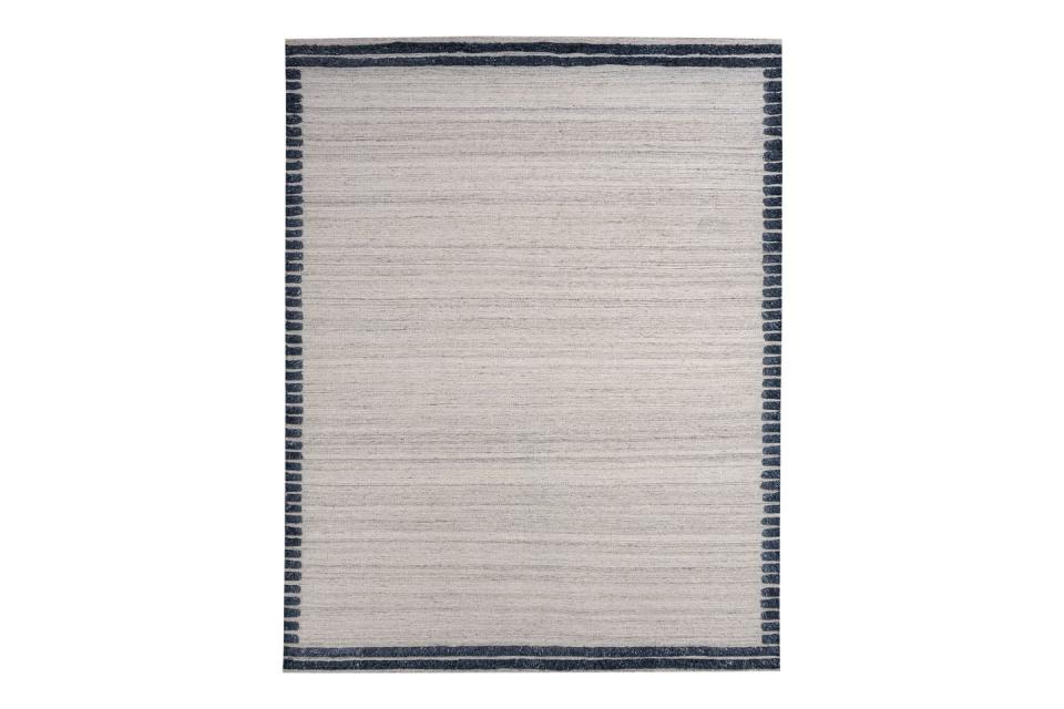 striated grayish rug withe blue and white striped border