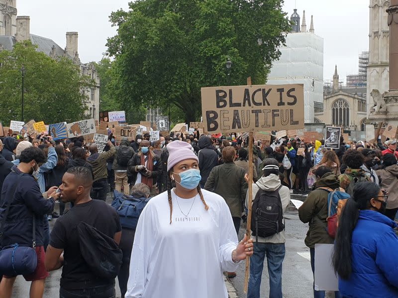 Demonstrators hold signs during a Black Lives Matter protest in Parliament Square, following the death of George Floyd who died in police custody in Minneapolis, in London