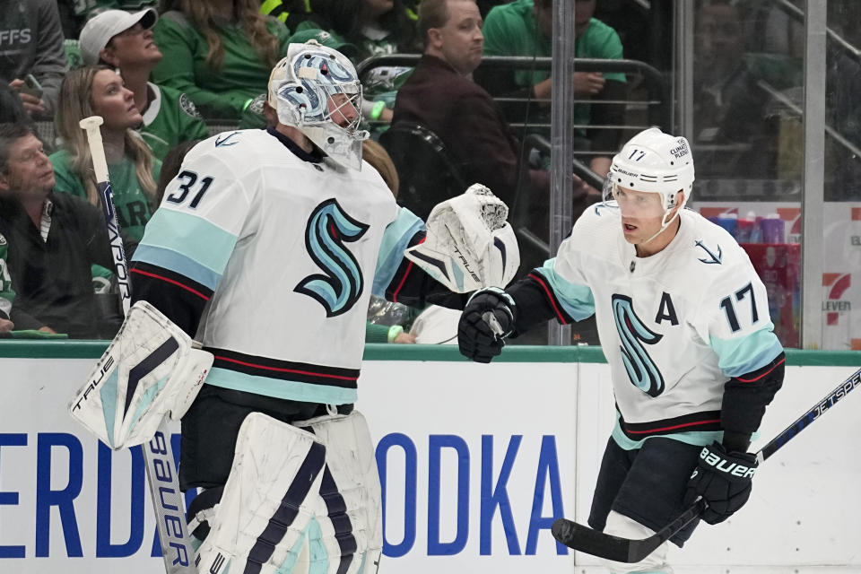 Seattle Kraken's Philipp Grubauer, left, and Jaden Schwartz, right, celebrate after Schwartz scored against the Dallas Stars in the first period of Game 1 of an NHL hockey Stanley Cup second-round playoff series, Tuesday, May 2, 2023, in Dallas. (AP Photo/Tony Gutierrez)