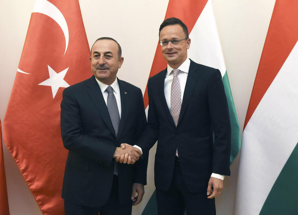 Hungarian Minister of Foreign Affairs and Trade Peter Szijjarto, right, welcomes Turkish Foreign Minister Mevlut Cavusoglu at the Ministry of Foreign Affairs and Trade in Budapest, Hungary, Friday, May 3, 2019. (Noemi Bruzak/MTI via AP)