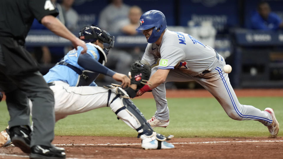 Toronto Blue Jays' Whit Merrifield (15) tries to beat the throw to Tampa Bay Rays catcher Christian Bethancourt while trying to score on a fly out by Kevin Kiermaier to left fielder Harold Ramirez during the seventh inning of a baseball game Saturday, Sept. 23, 2023, in St. Petersburg, Fla. Merrifield was tagged out on the play. (AP Photo/Chris O'Meara)