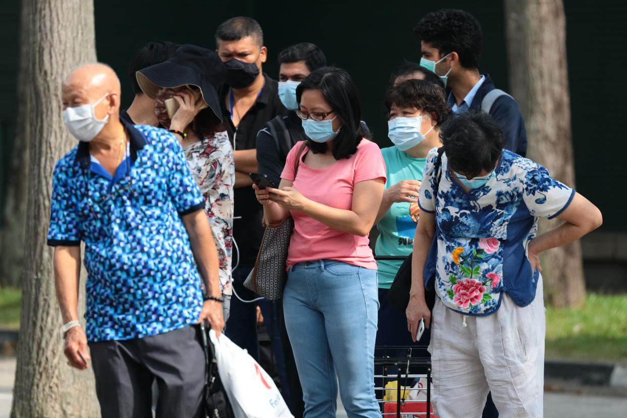 People wearing protective mask wait in queue to take their COVID-19 antigen rapid test outside a quick test centre on October 16, 2021 in Singapore. (Photo by Suhaimi Abdullah/NurPhoto via Getty Images)