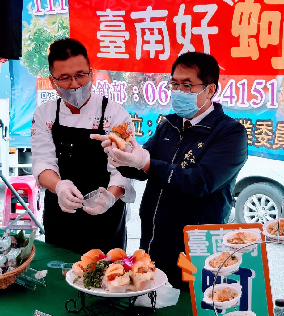 大台南西餐工會理事長邱英洋（左）、台南市長黃偉哲（右），示範鮮蚵可樂餅漢堡等料理製作訣竅。（記者羅玉如攝）
